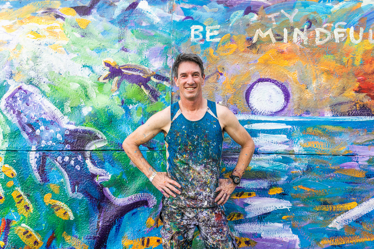 Phil Doncon, Paint Storm, in front of one of his artworks from the 2019 Ningaloo Whale Shark Festival