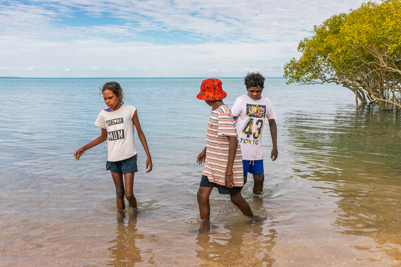 Three indigenous children in the bay by the mangroves in Broome, WA