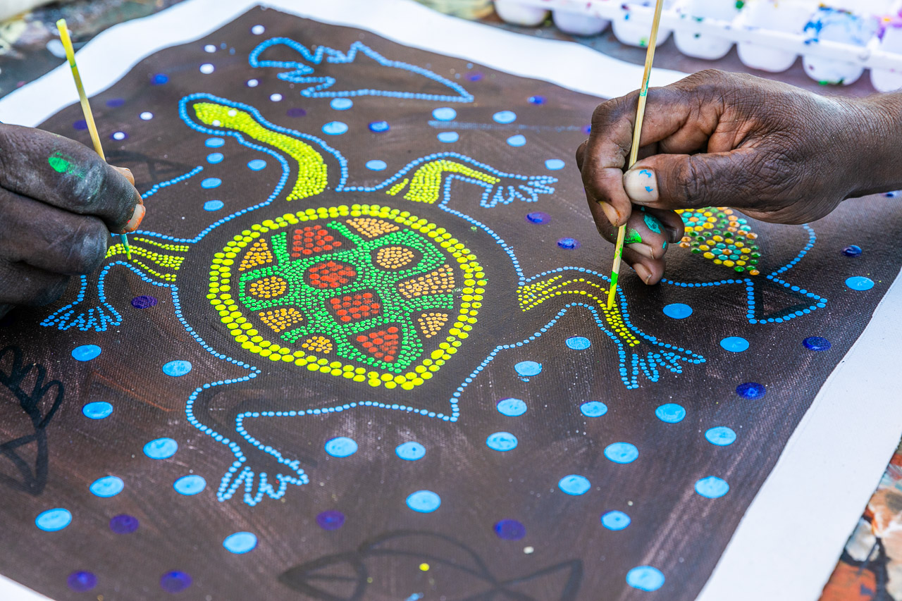 Two hands painting a long neck turtle at the Norval Gallery in Derby