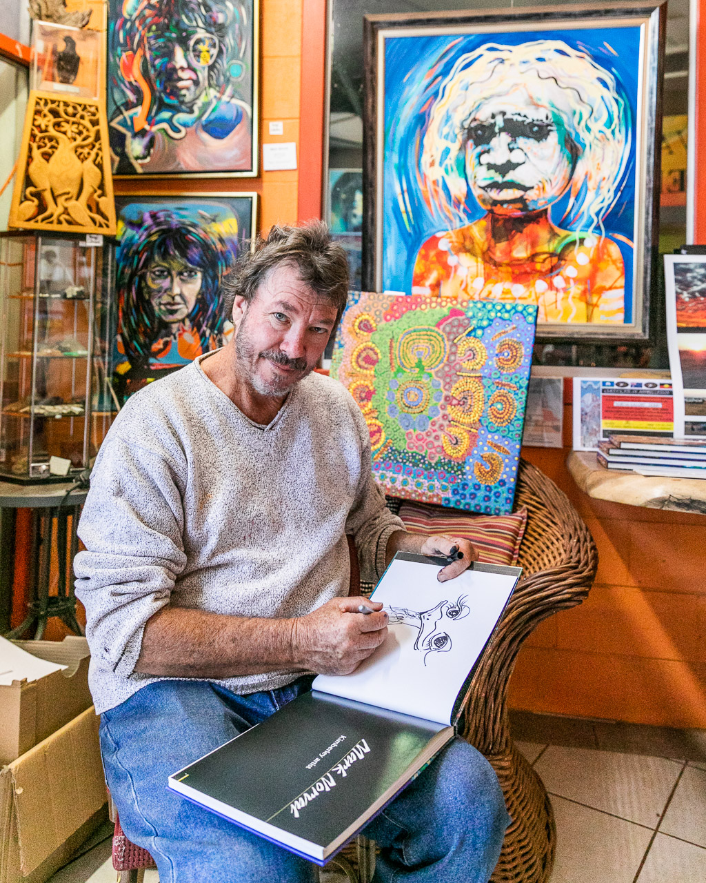 Artist Mark Norval signing a copy of his book in his Derby gallery in Western Australia