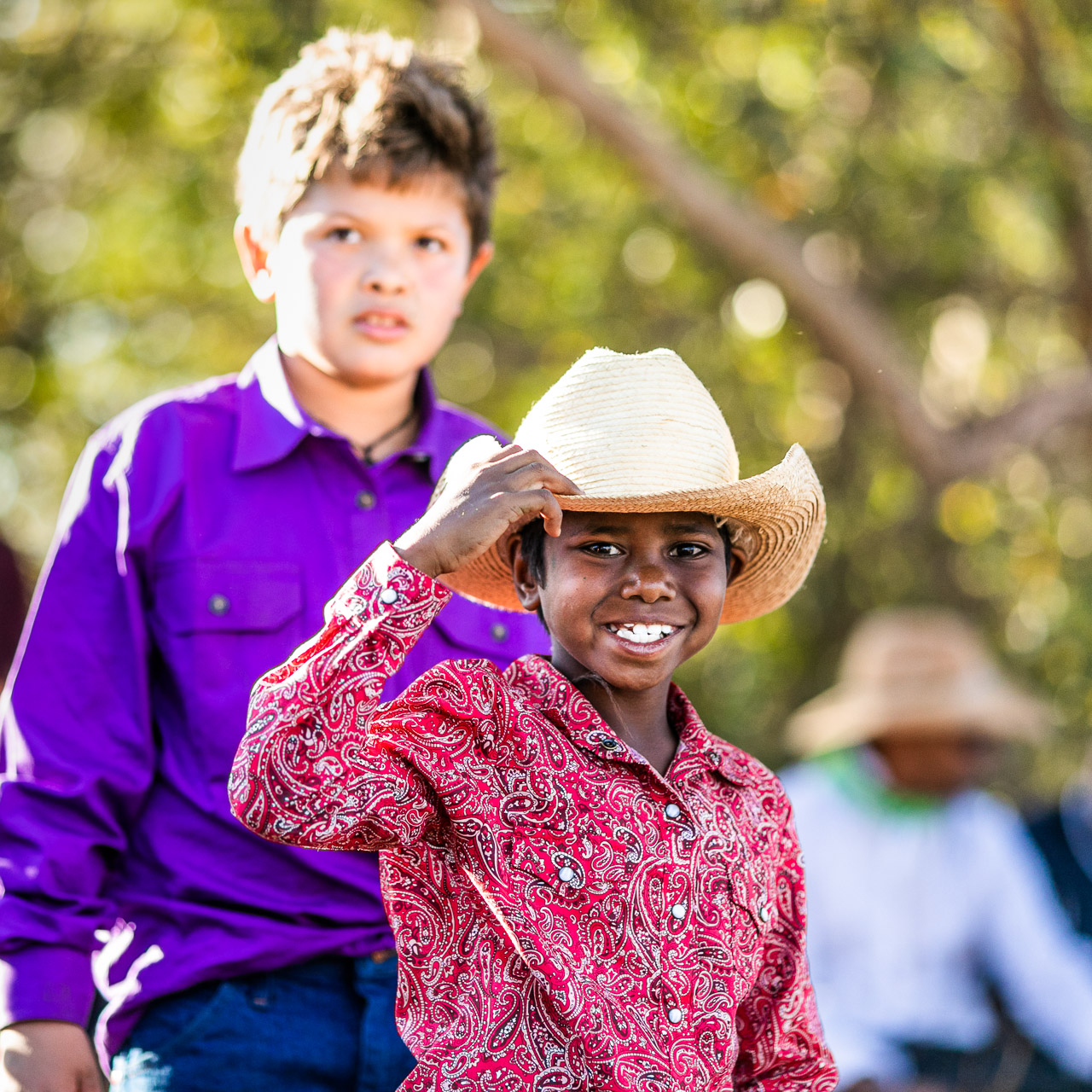 Aboriginal boy in a bright shirt and cowboy hat at the Broome Rodeo