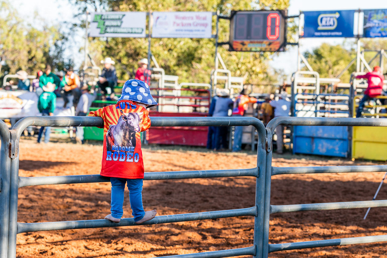 Small child standing on the railings at the Broome Rodeo 2019