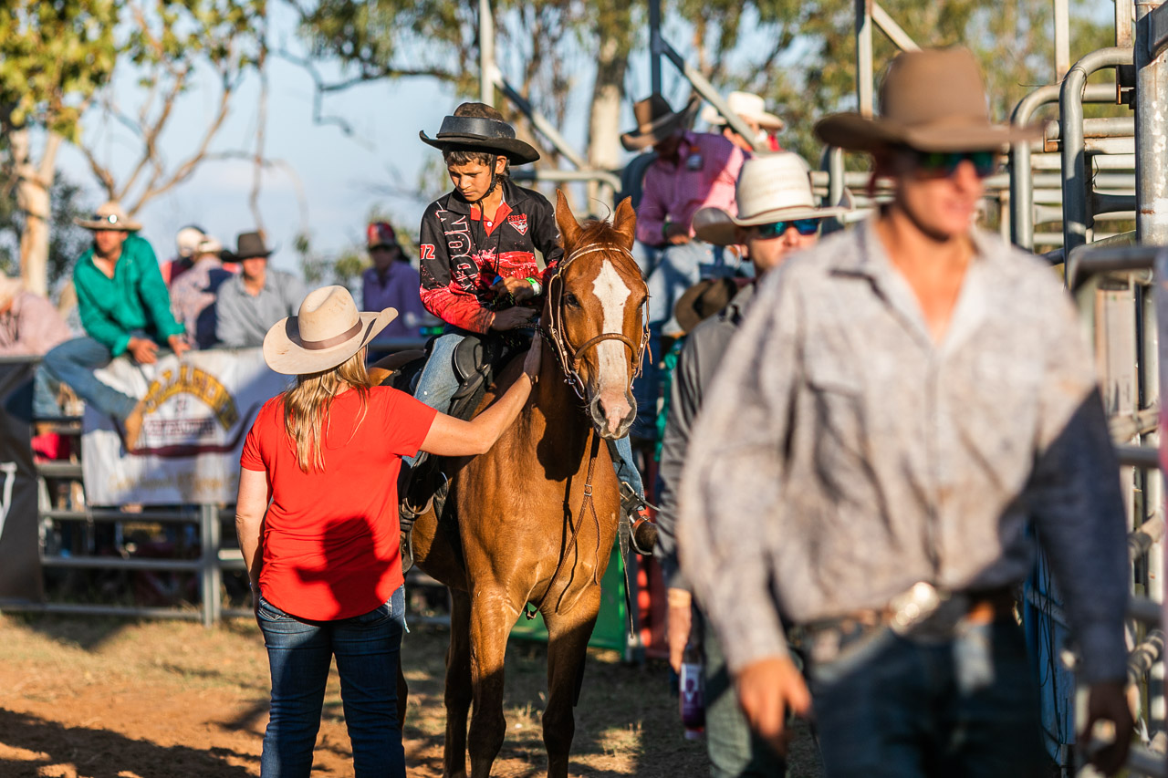 Child rider at the Broome Rodeo, on his horse and talking to an adult