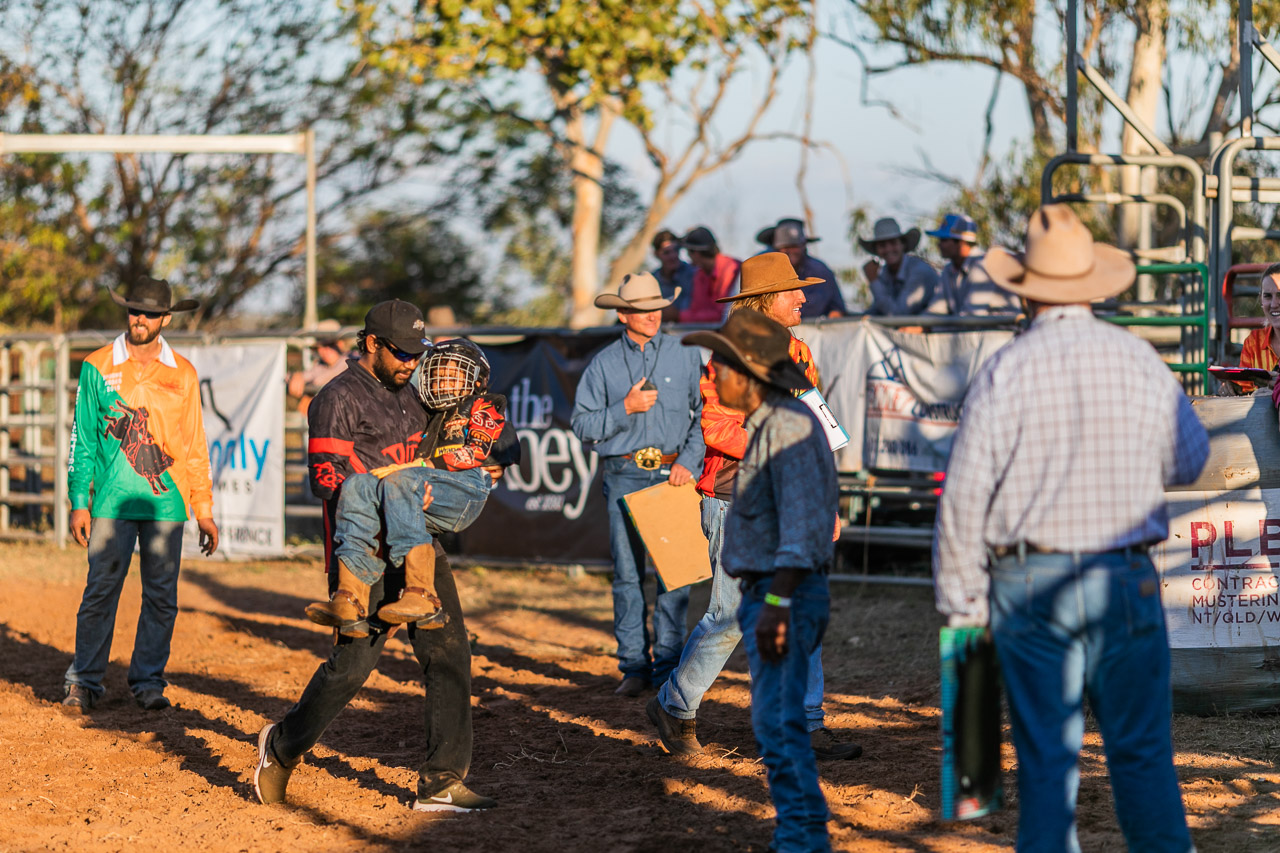 A young rodeo rider is carried out of the arena after a fall