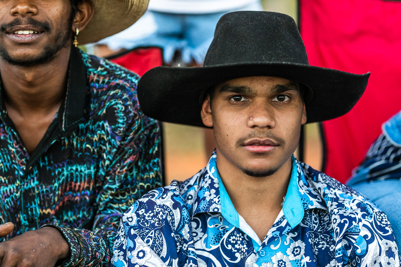 Young man in a bright shirt and a black cowboy hat at the Broome Rodeo