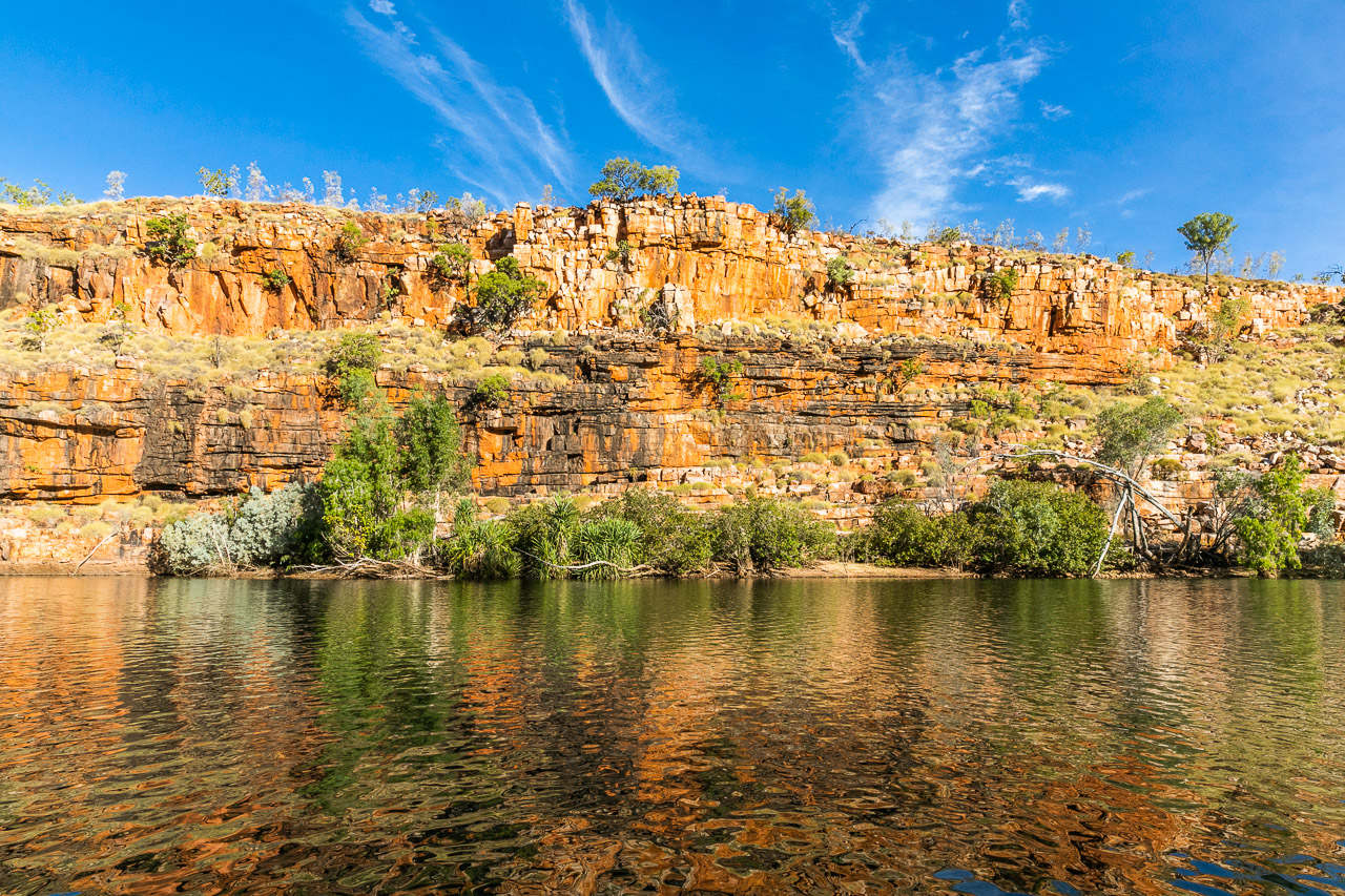 Deep red rocks reflected in the water at Chamberlain Gorge in the Kimberley