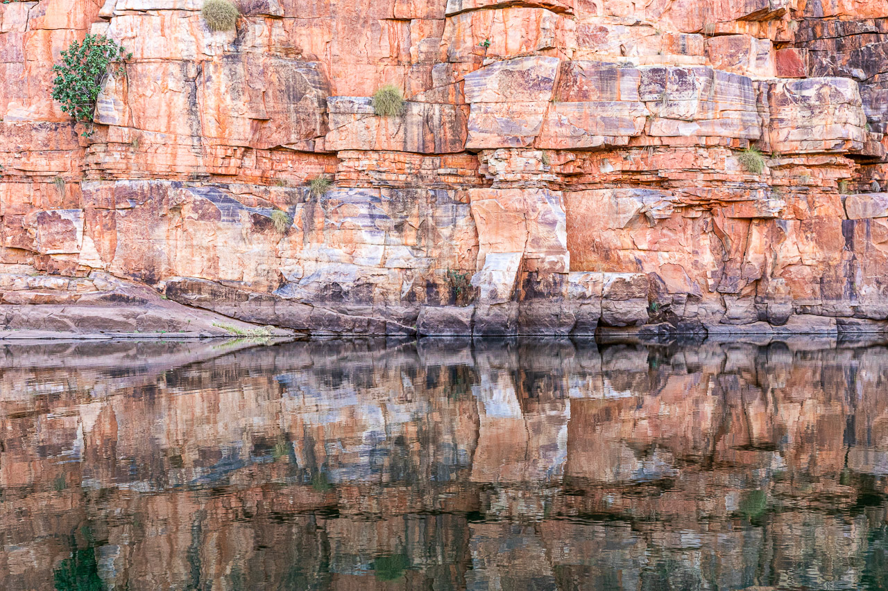 Red rocks reflected in still waters at Chamberlain Gorge, El Questro in the Kimberley region of Western Australia