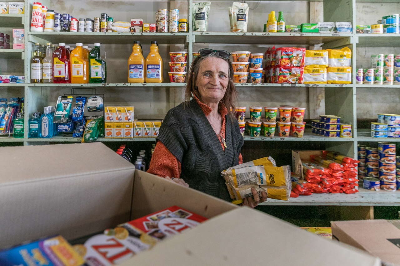 Pauline, unpacking boxes and restocking shelves at Bell's Emporium in Cue