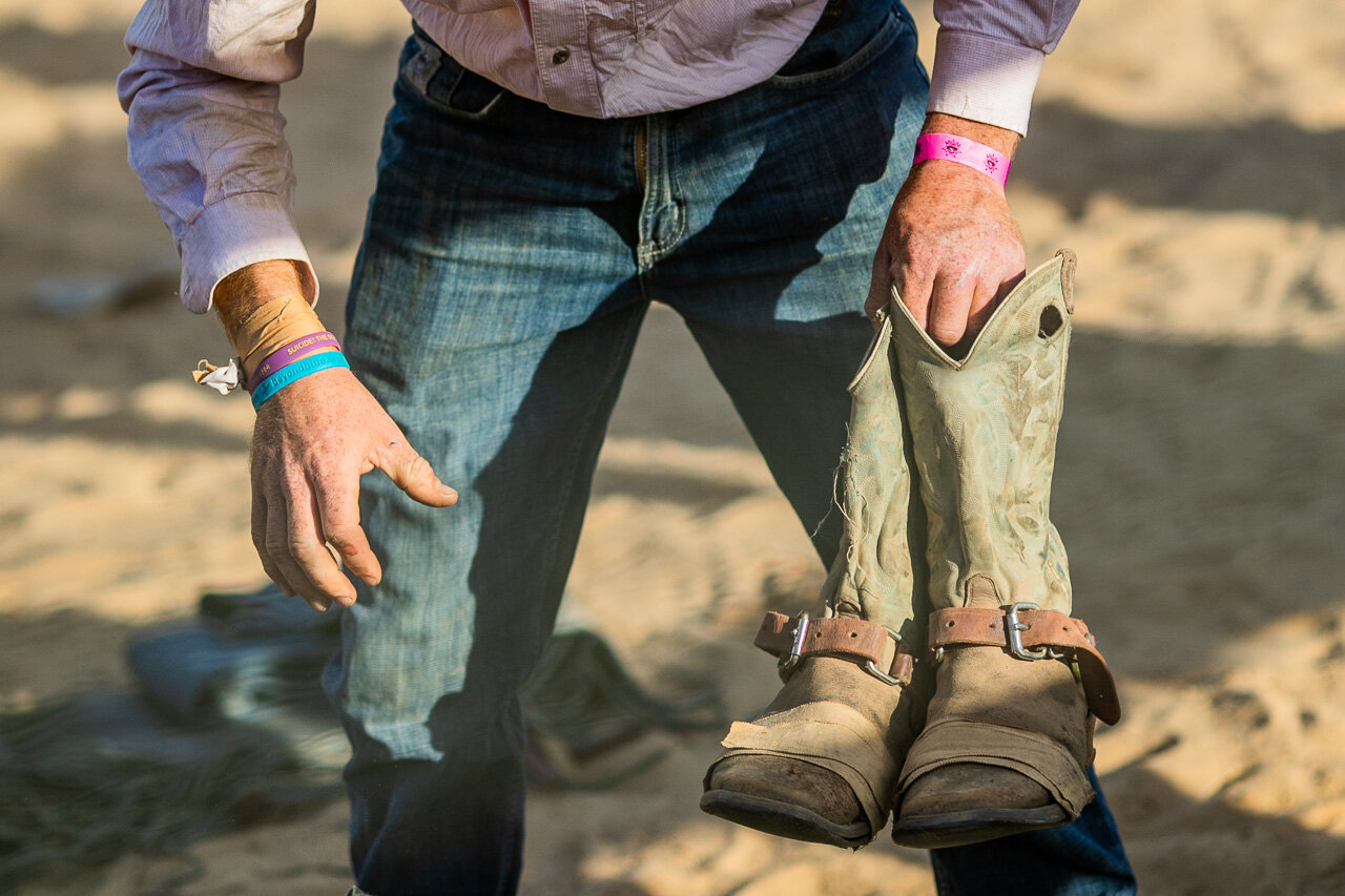 Cowboy packing away his cowboy boots at the end of another rodeo 