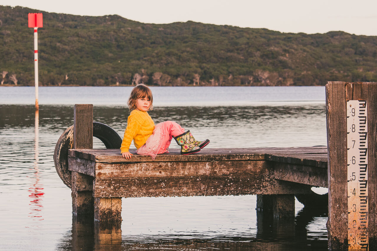 Girl wearing colourful clothes on the jetty at Wilson Inlet in Denmark on the south coast of Western Australia 