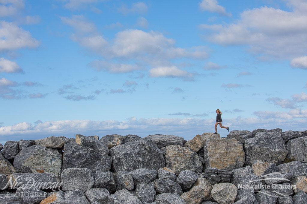 Girl walking on the sea wall at Augusta Marina