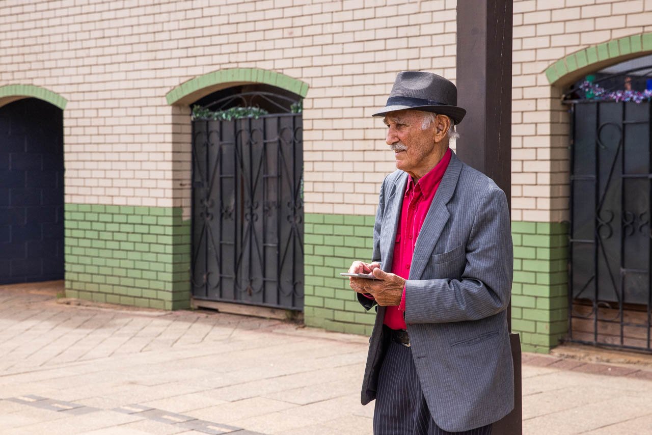 Characterful elderly gentleman texting on his iPhone