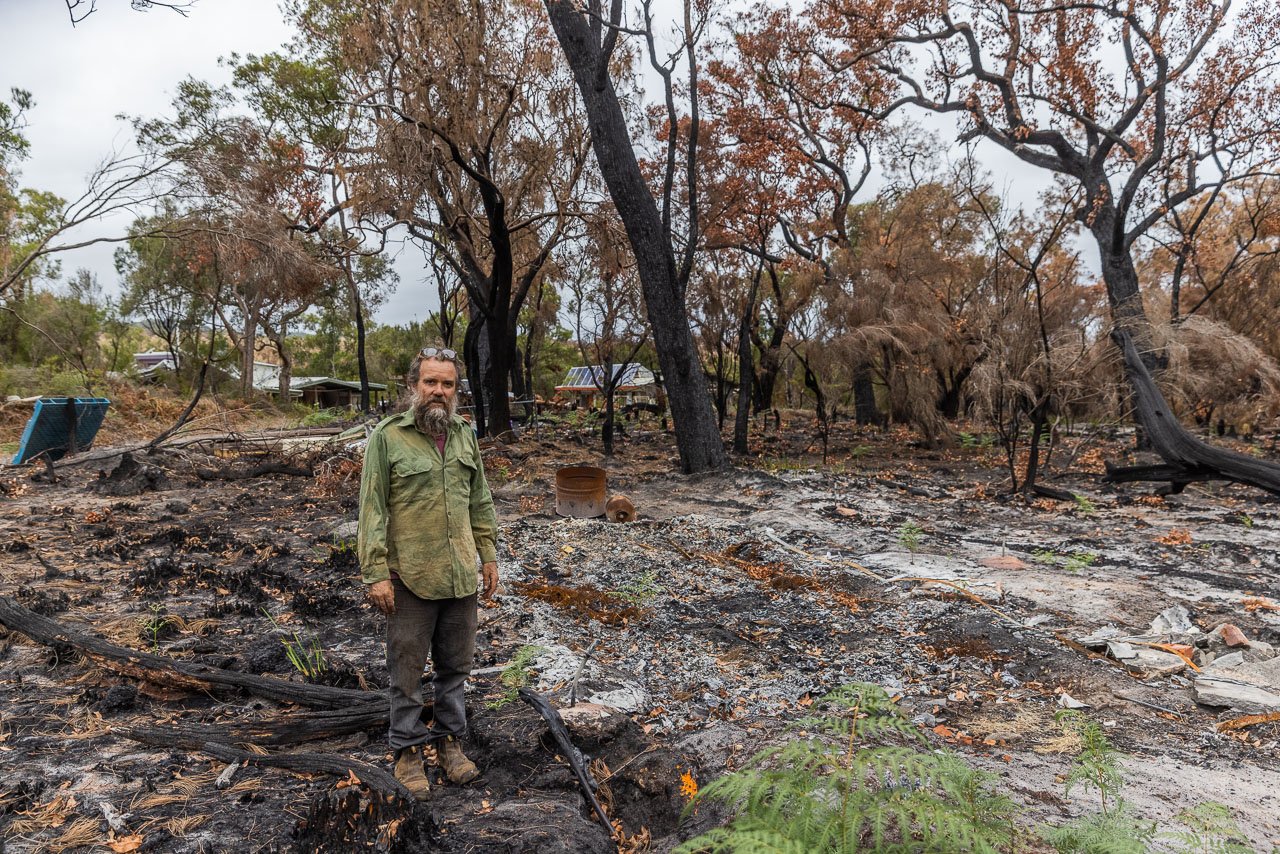 Denmark resident James Gentle standing next to the remains of his caravan after the Denmark bushfire. The image shows how close the fire came to his home in the bush.