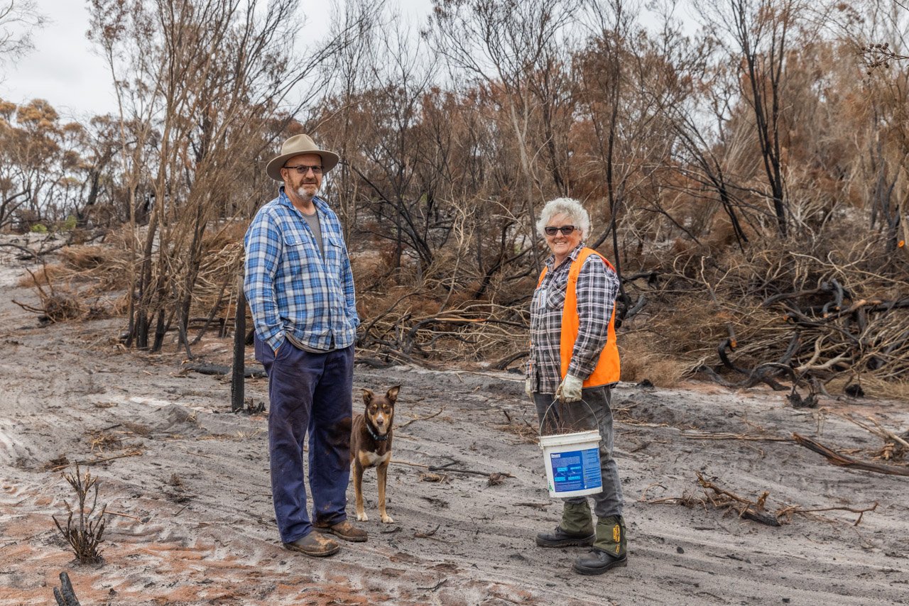 Two BlazeAid volunteers amongst the burnt landscape