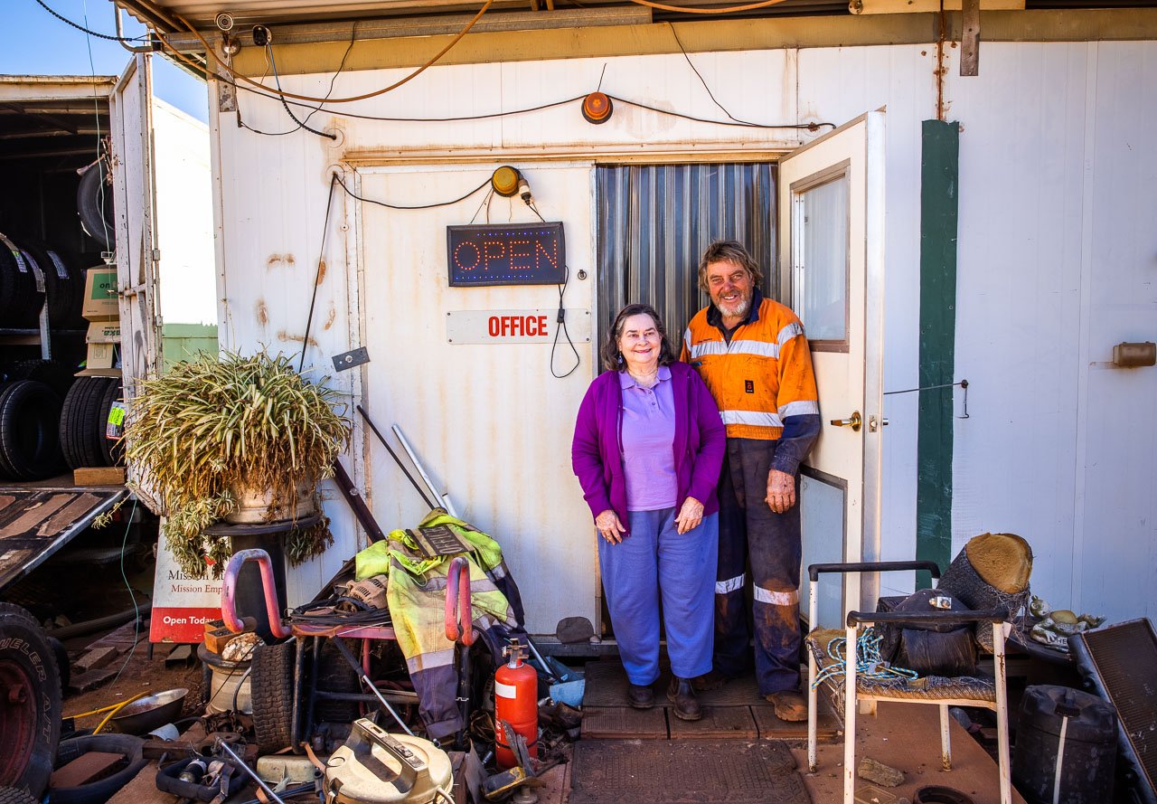 Couple standing outside the door of their office in the industrial estate area of Leonora, WA