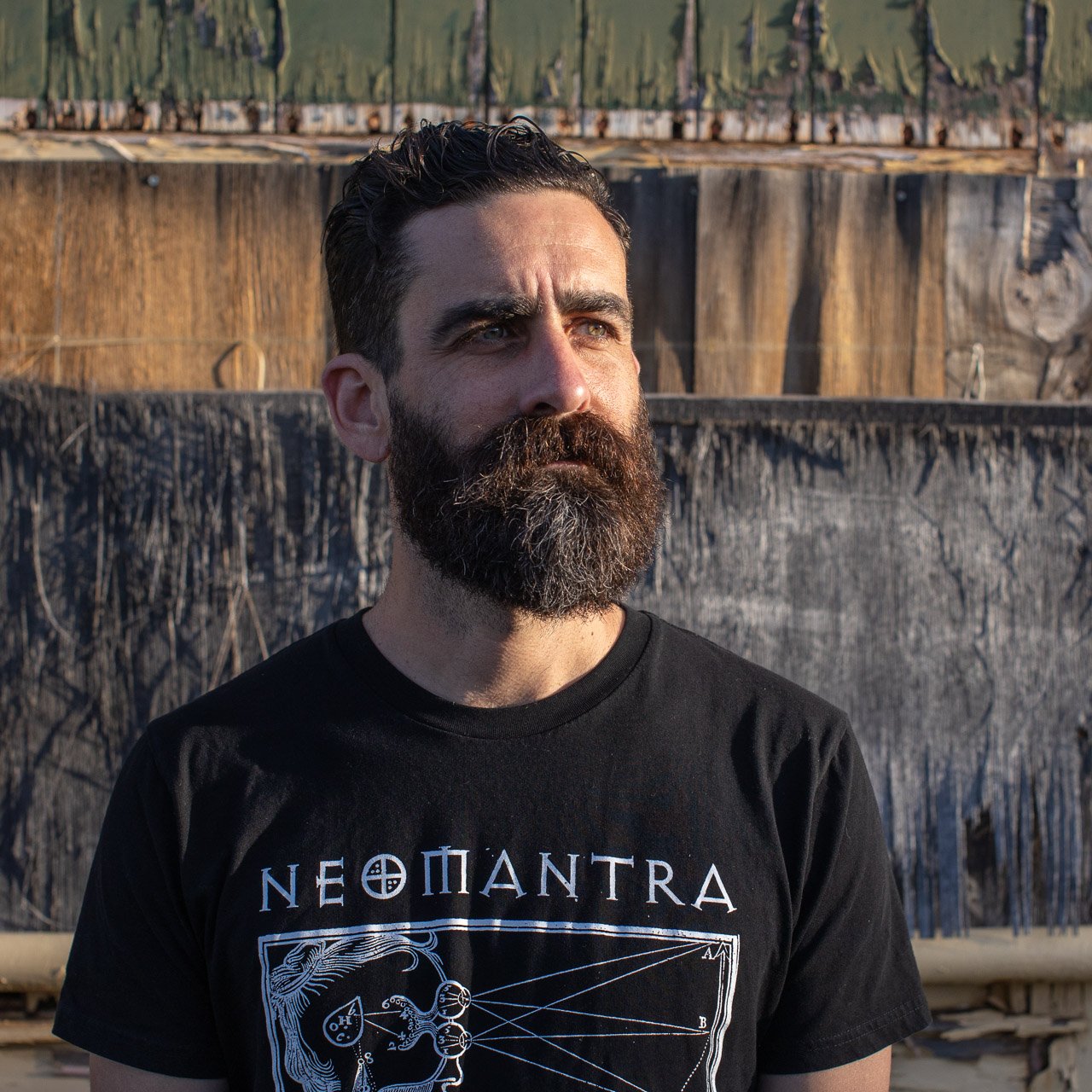 Bearded man in front of a textured background of peeling paint