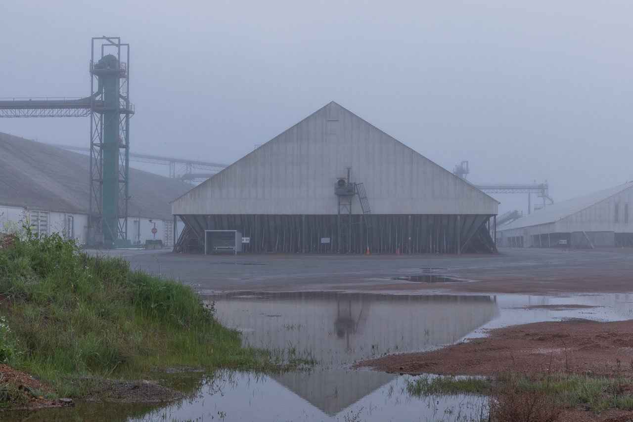 The grain bin in Kulin reflected in a puddle on foggy morning