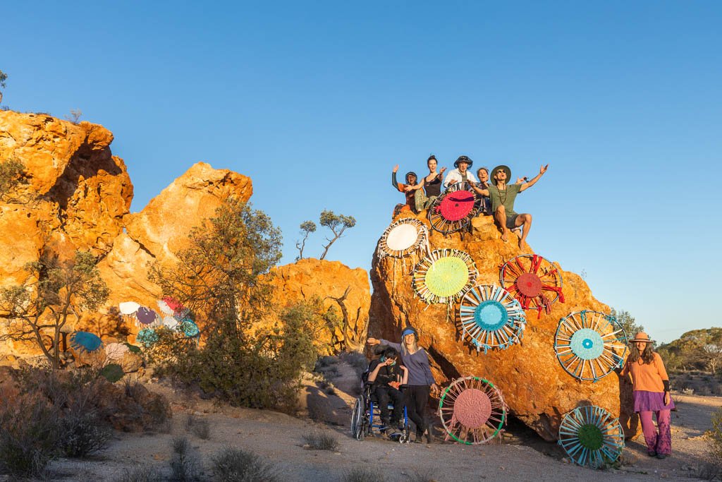 The participants of the 2023 Reclaim the Void camp with the rugs they wove that week