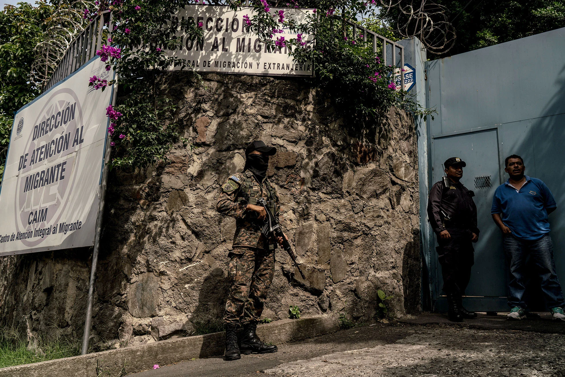 A member of the military stands guard outside the Migration center in San Salvador on Thursday, June 21, as people wait for their family members who were deported from the US.