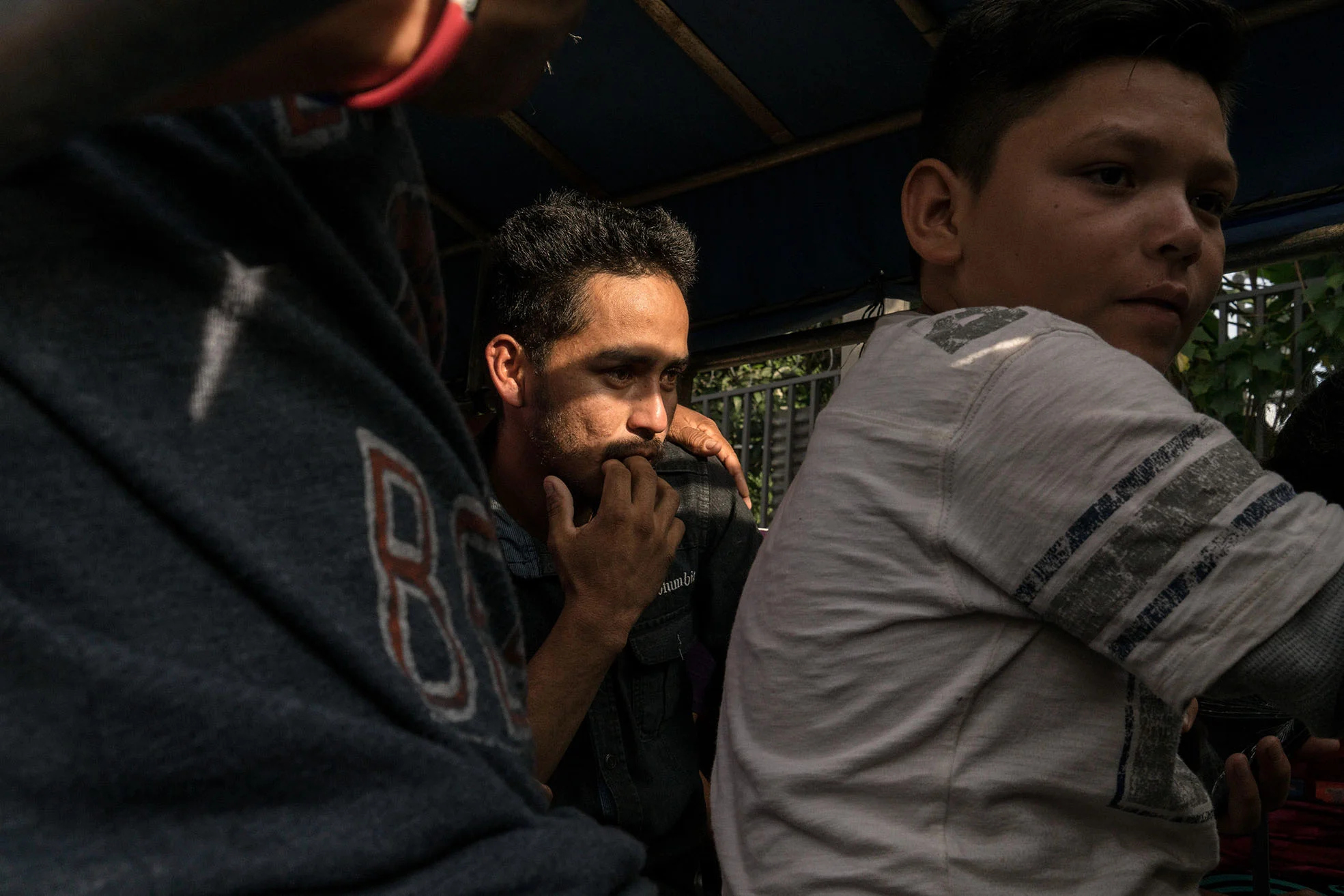 Arnovis Guidos Portillo sits with family who fetched him at the Migration Center in San Salvador on June 21.