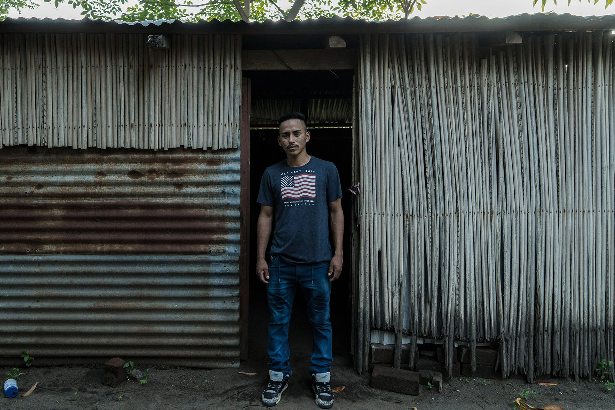 Arnovis Guidos Portillo poses for a portrait outside his house in Corral de Mulas, El Salvador, June 22, 2018.