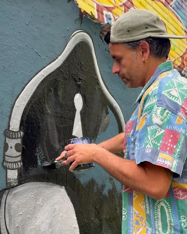 Artist Skount painting the Beyond the Threshold mural in Amsterdam inspired by cosmic portals and contemporary surreal street art.