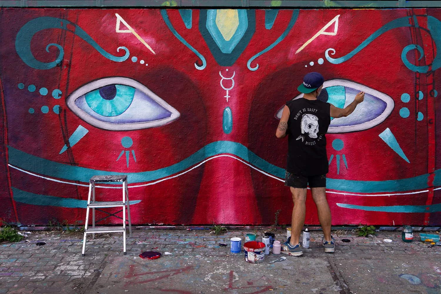 Artist Skount painting the Blinking stop motion mural in Amsterdam, creating layered eyes for the animation project
