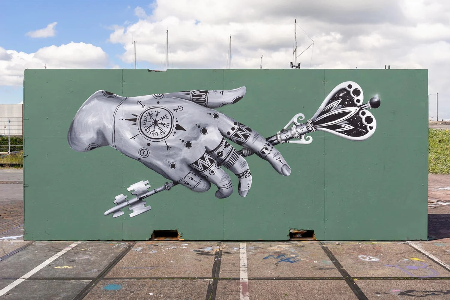 Mural by Skount of a hand offering a key, symbolizing spiritual gateways and inner discovery.