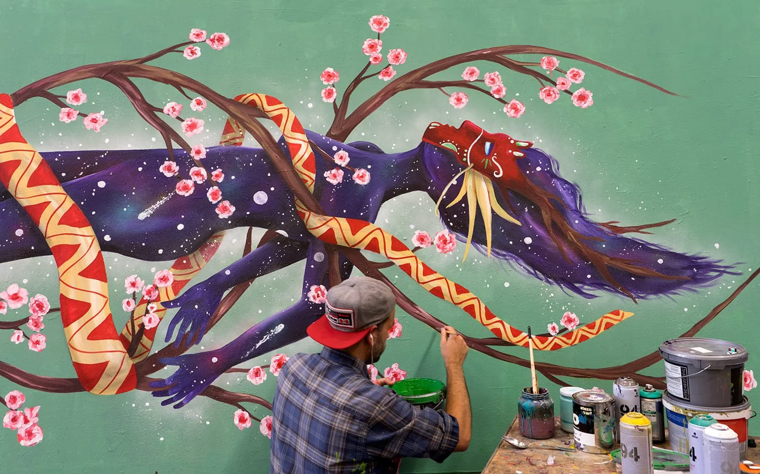 Skount painting the Helix mural on a billboard in Amsterdam