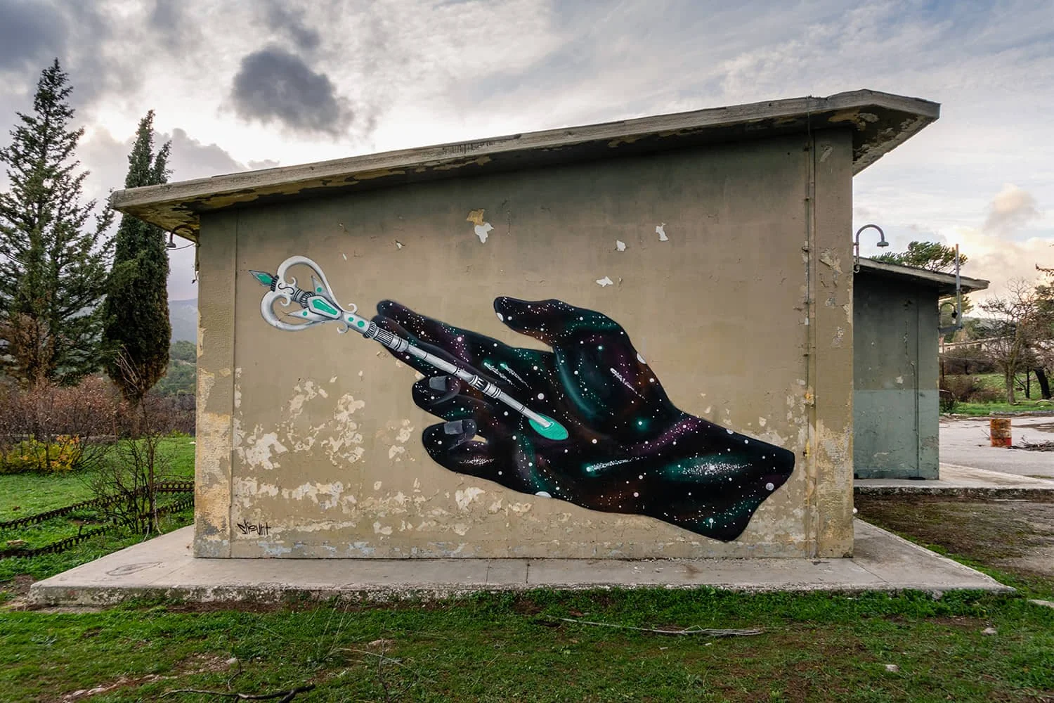 Mural by Skount of a cosmic hand holding a key, representing spiritual portals, discovery, and symbolic connection.