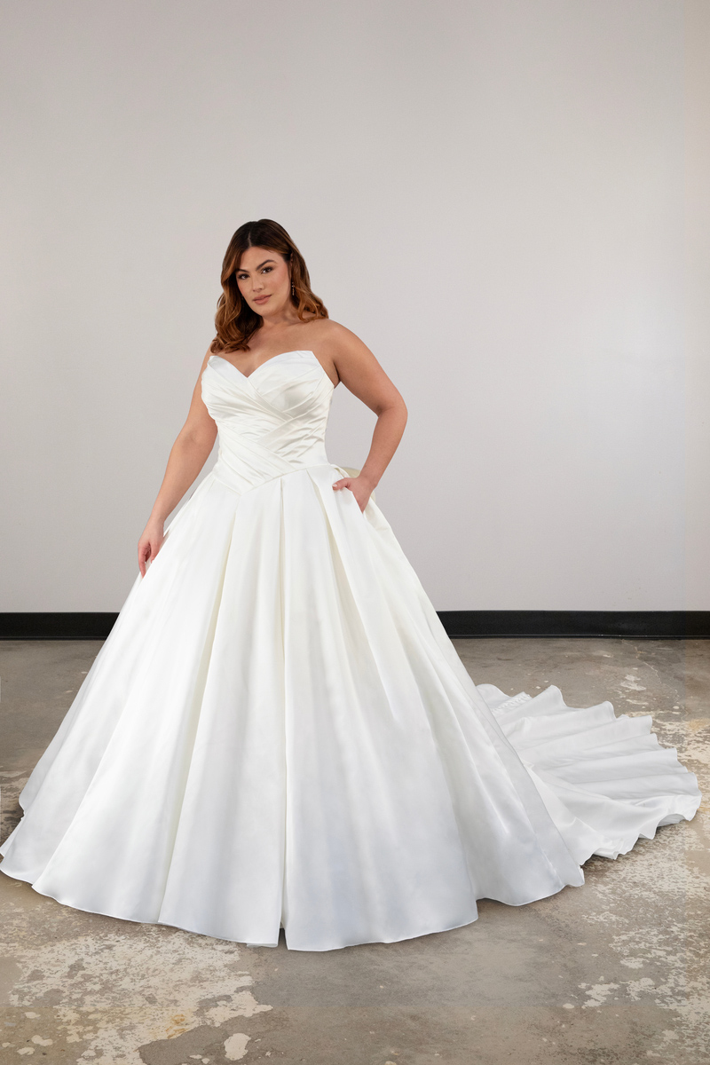 A ballgown princess style wedding dress featuring a Basque waist, sweetheart neckline, ruching on the bodice, and a pleated skirt