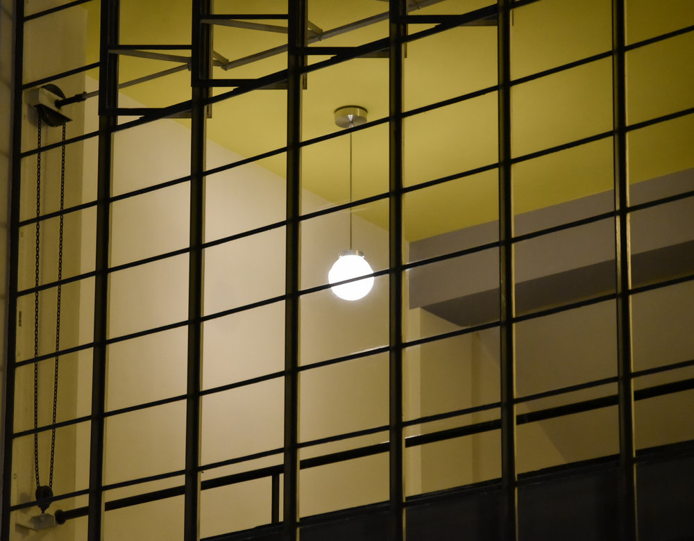 Marianne Brandt light shines through glass of Bauhaus Building.