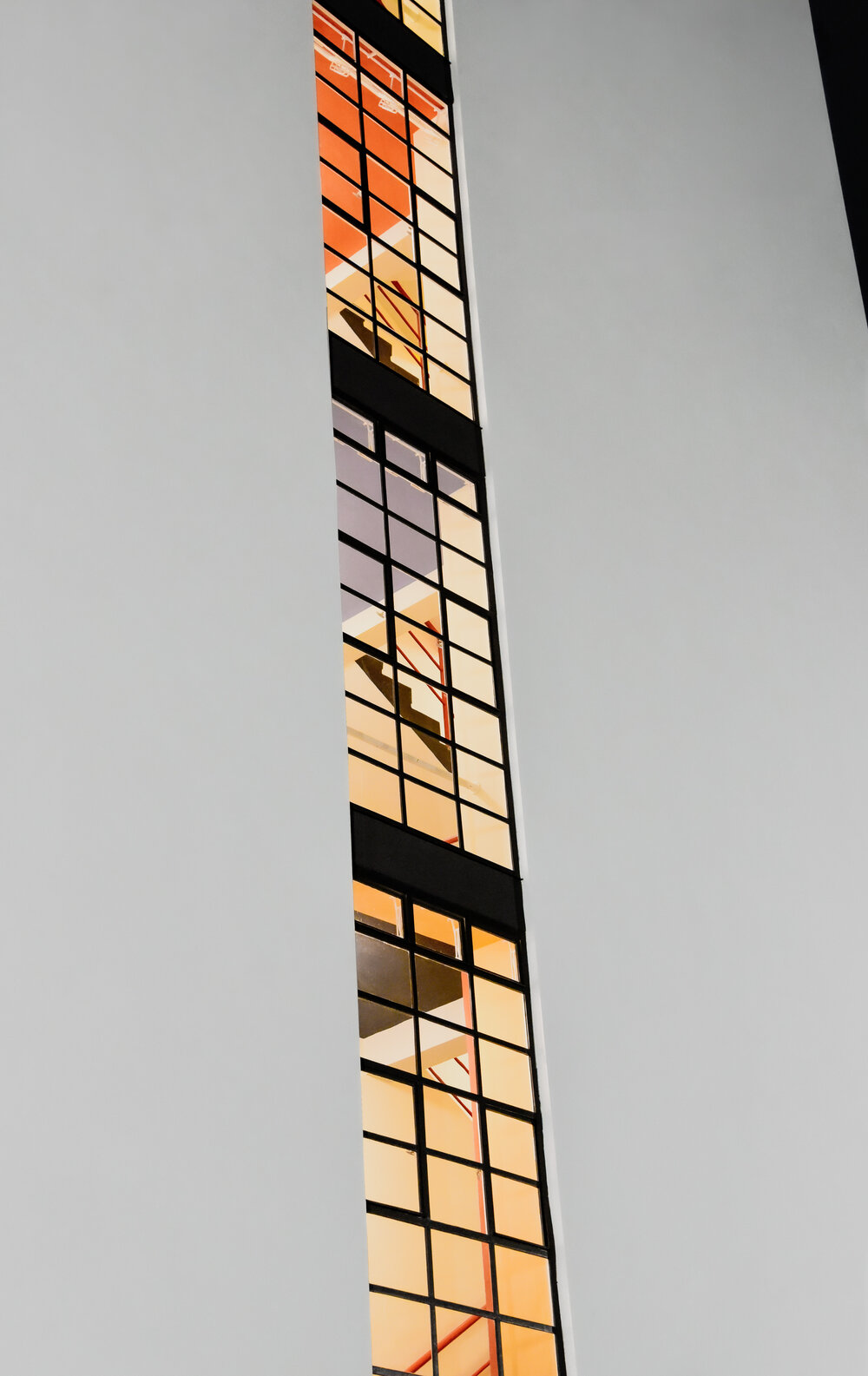 Bauhaus Building stairwell window shows varied floor colors.