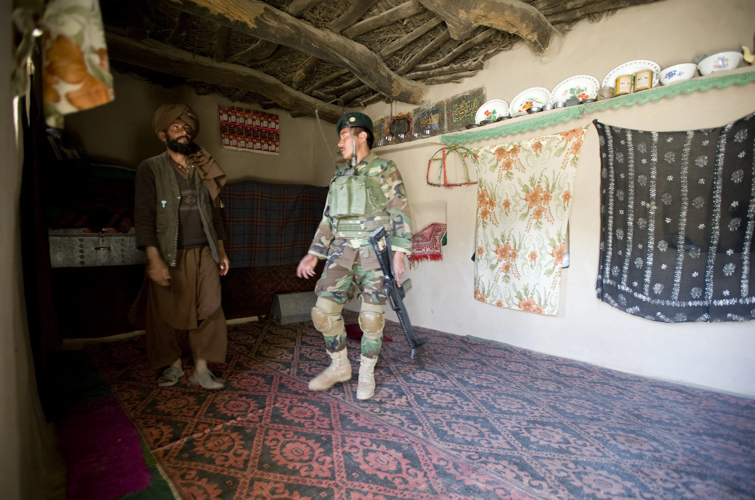 Afghan soldiers search a house in Jugyan, Shinkay district, Zabul province, minutes after an American paratrooper was shot and injured there by a sniper. March 2010.