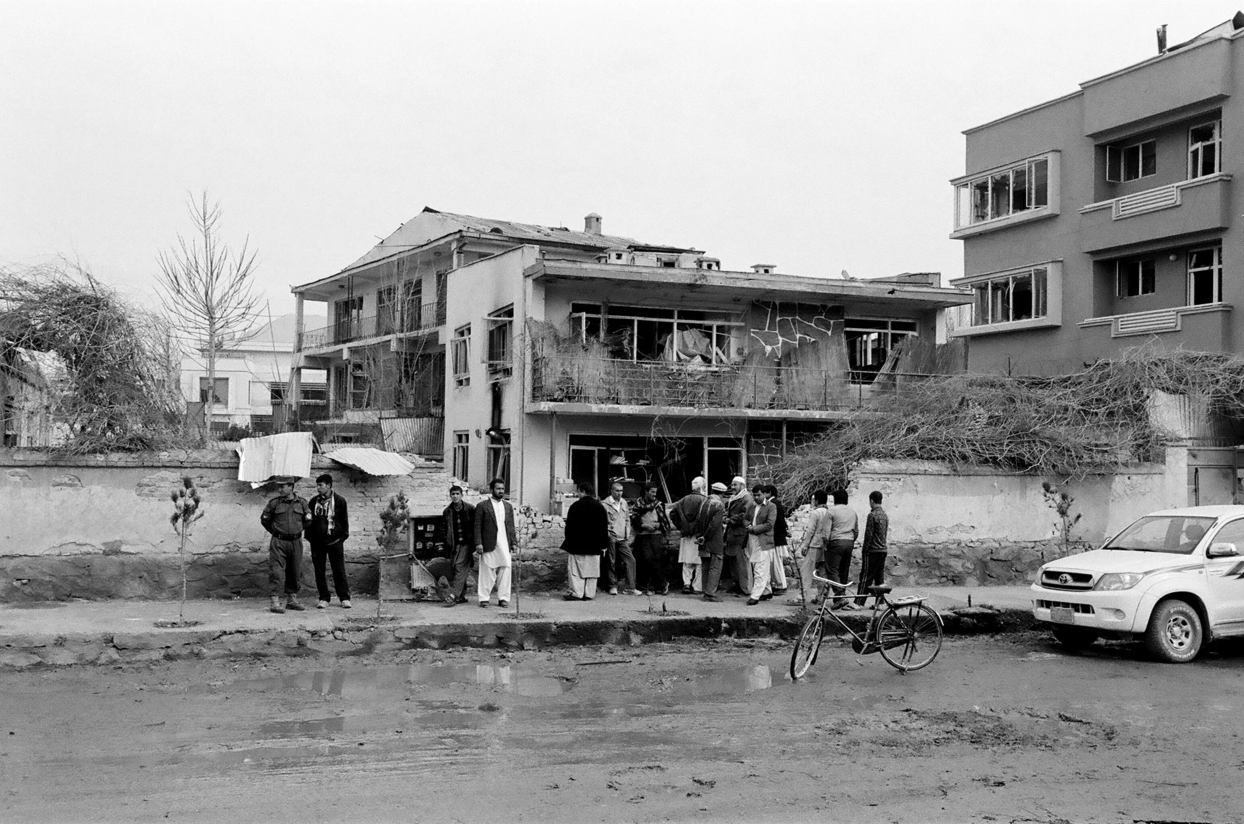 Onlookers gather the morning after an attack by the Taliban on a guest house in Kart-e-Se, Kabul. The insurgents accused the foreigners of being Christian missionaries - a claim supported by local residents. March 2014.