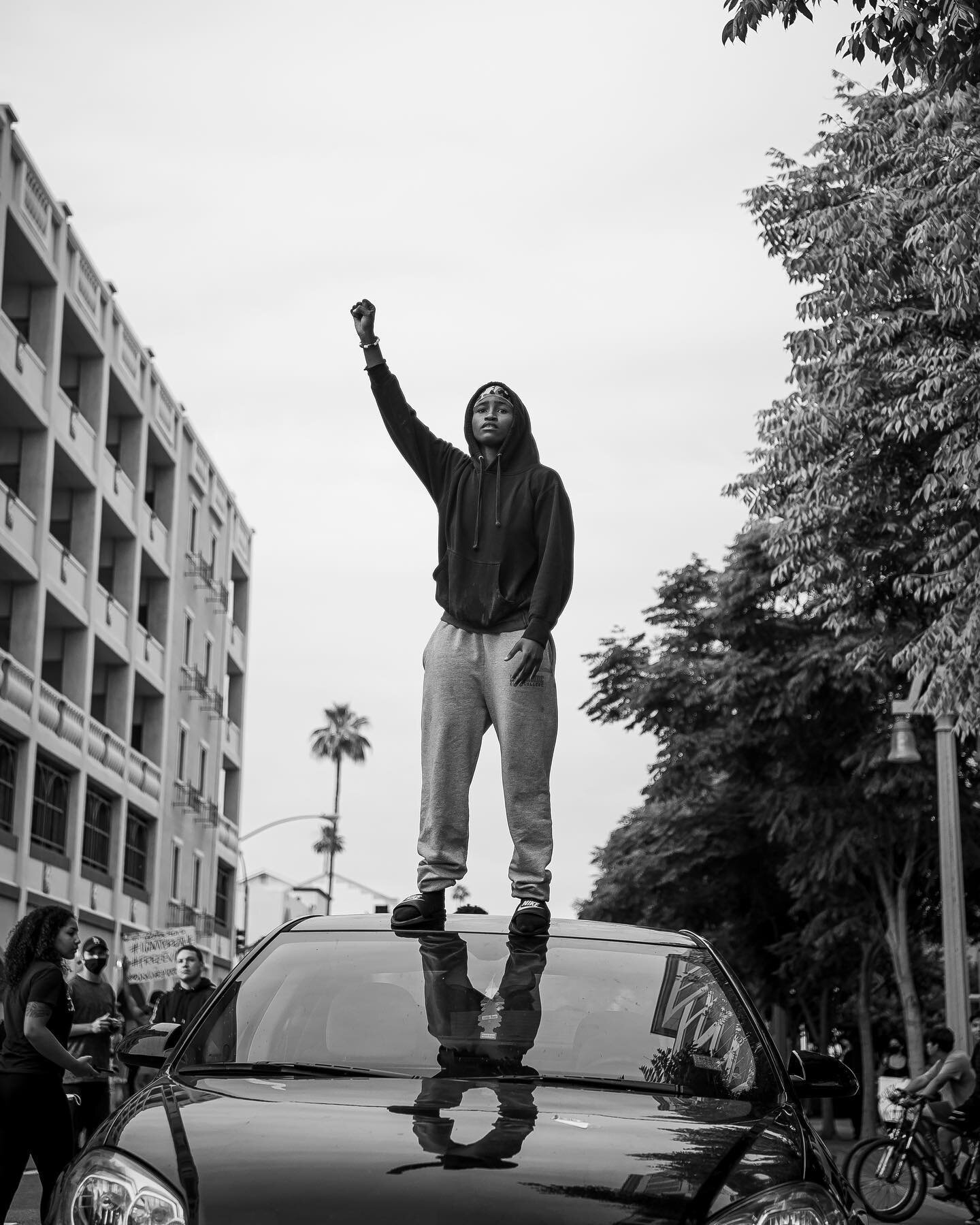 BLM  i. - 6.1.2020
i - this young Black woman stood on her car speaking words of encouragement and uplift everyone around her while holding her first in the air the whole time✊🏽
ii - &quot;White silence = Violence&quot;/&quot;Hands up, don't shoot&q