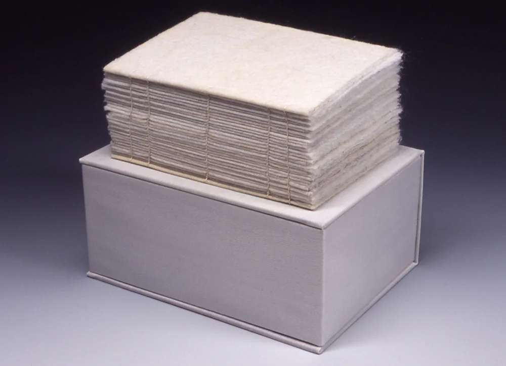 The Book According to 96 Loads | 2003 | Box: 7.4" L by 5.5" W by 3.5" H Book: 6.5" L by 4.5 " W by 3.2" H | Dyer sheets, foam, book board, and wax string