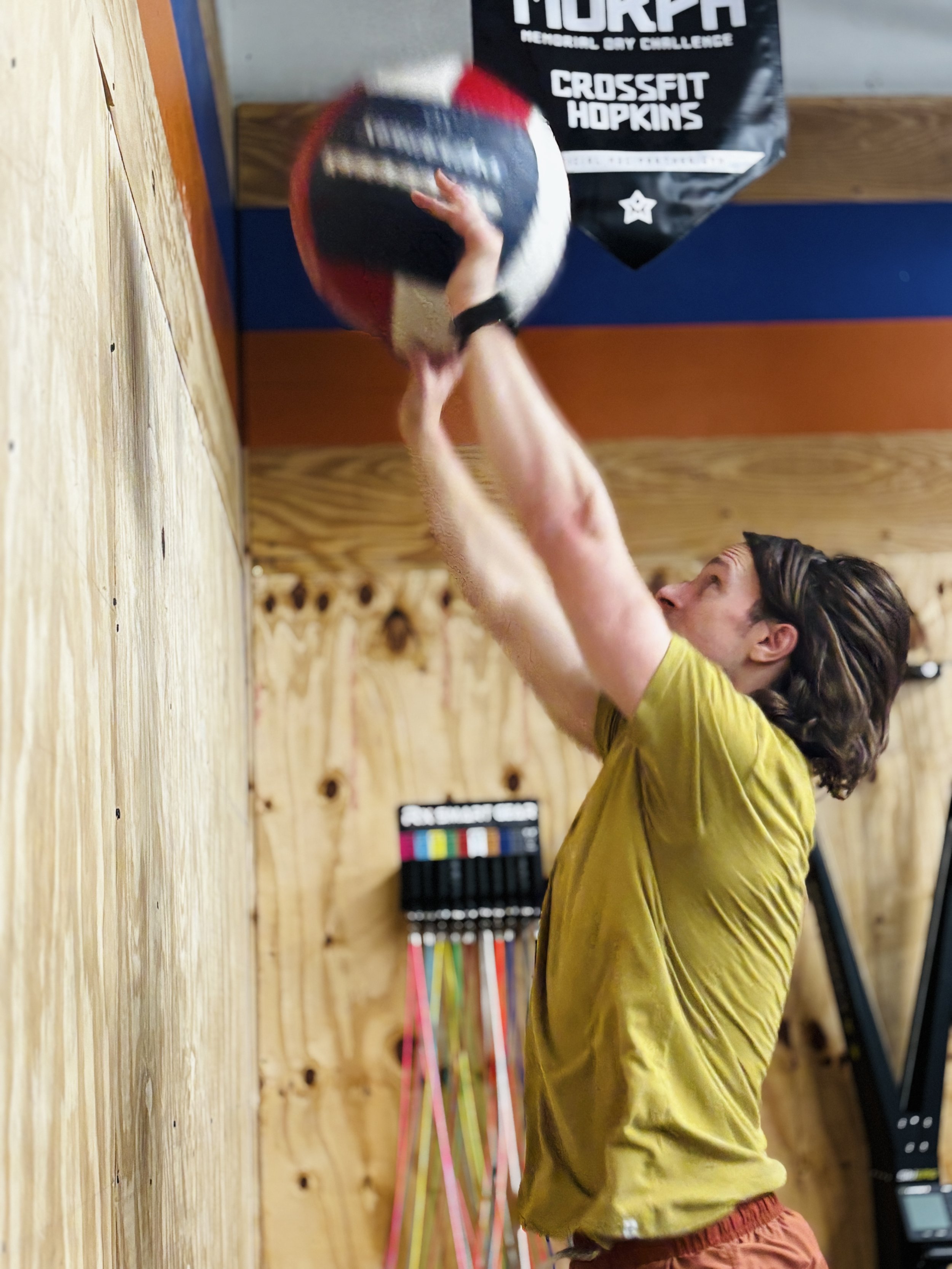 Man throwing a medicine ball to a target on a wall