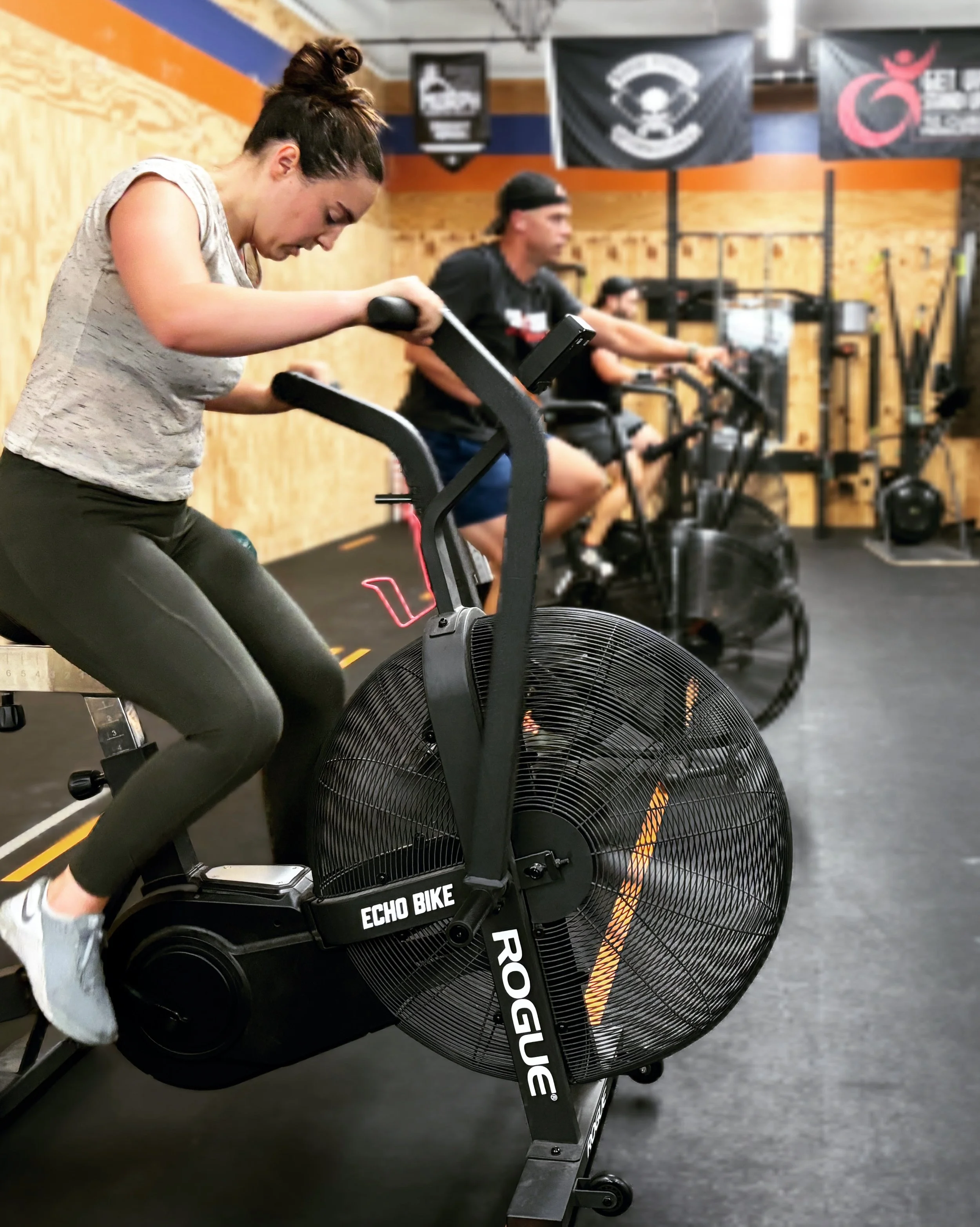 CrossFit members in the gym riding stationary bikes