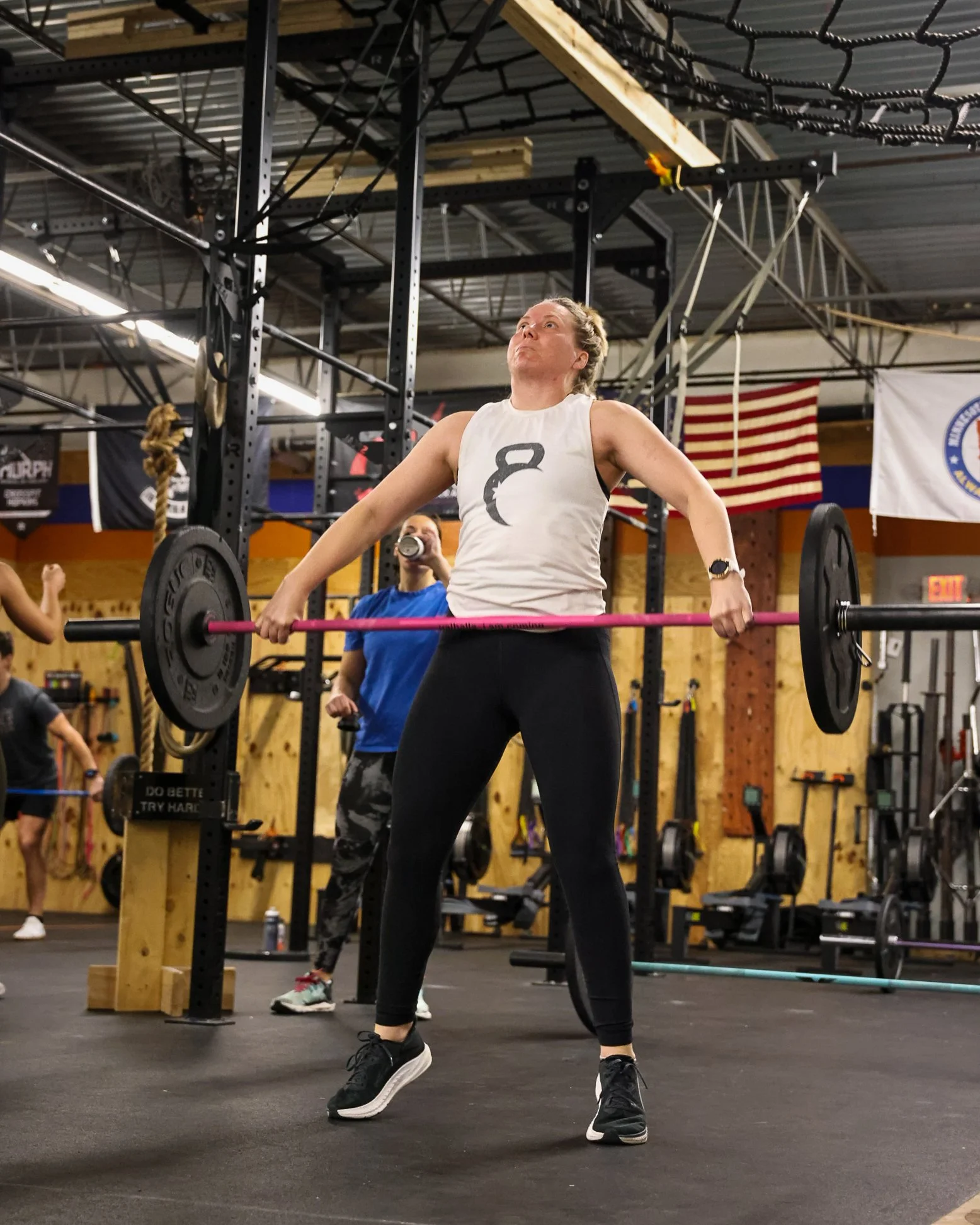 Woman in a gym doing a barbell clean