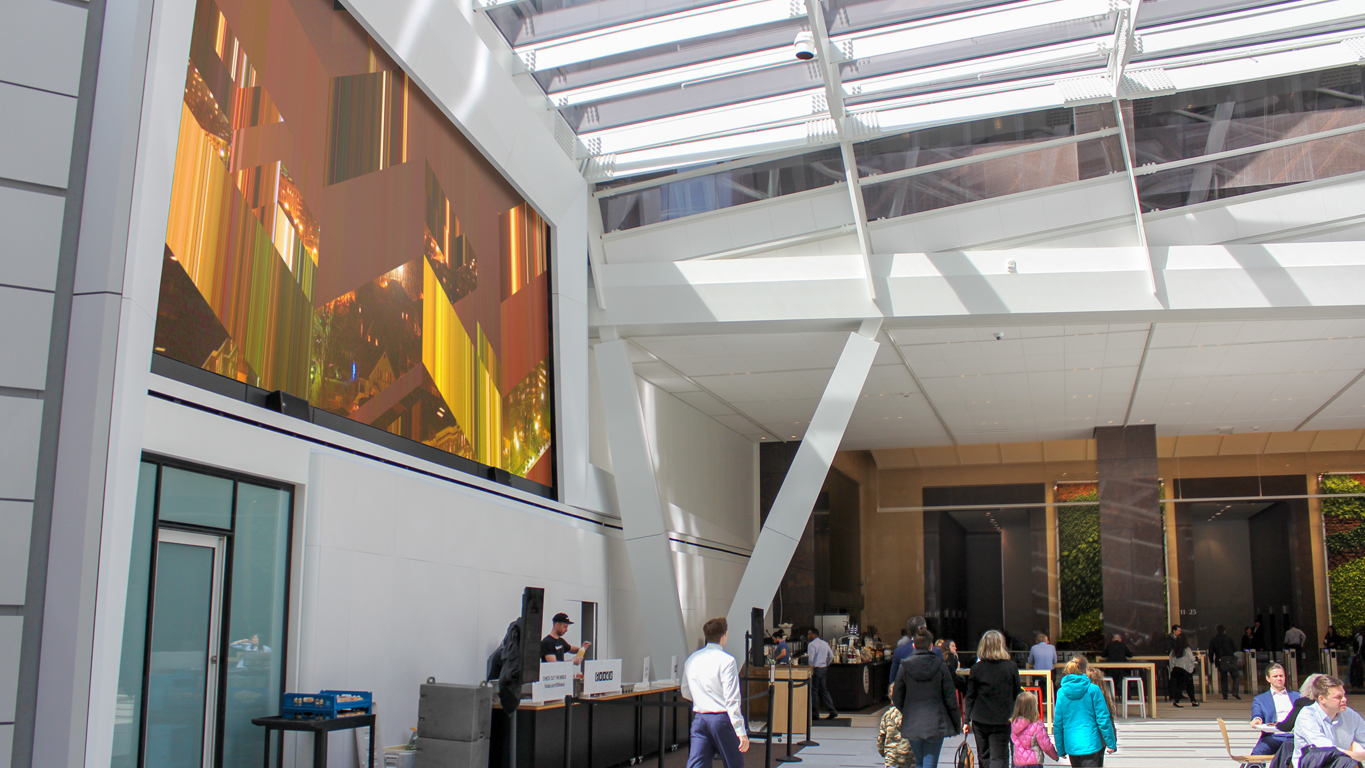 The LCD artwork weaves strips of yellow, red, and gold, evoking its source photograph of a Boston night skyline.