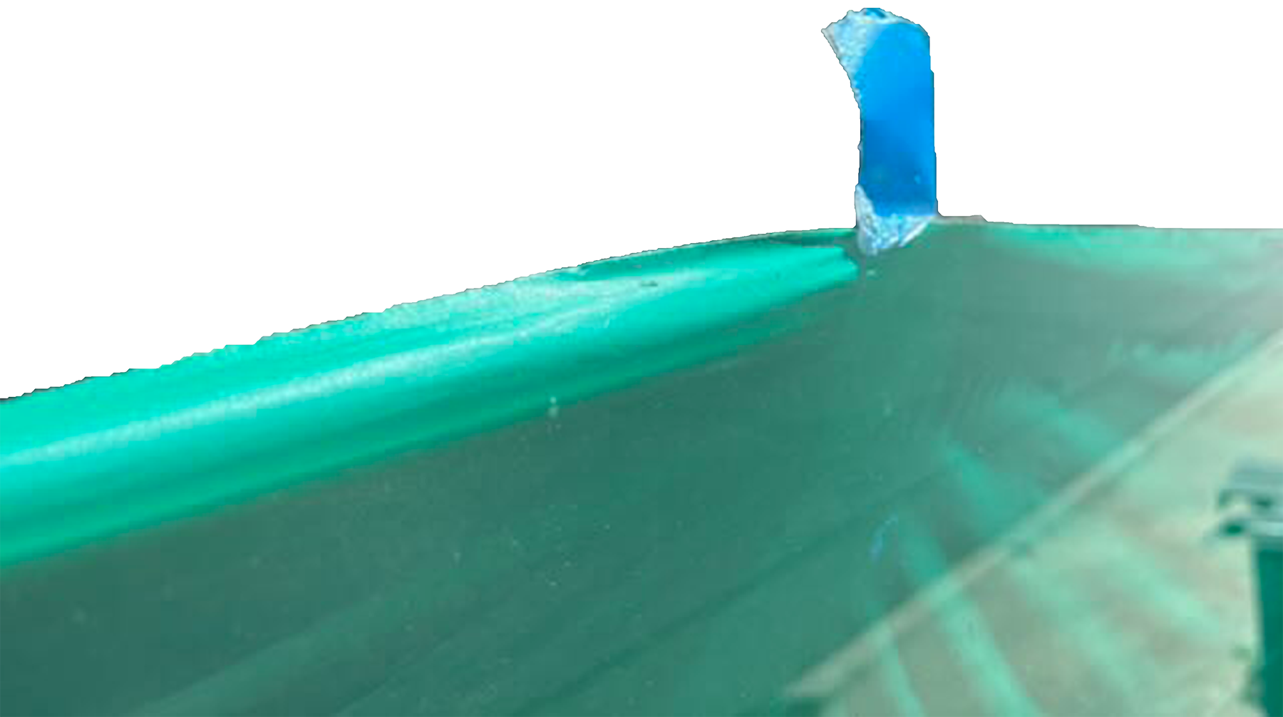 Close-up of a green tarp held taught at one point by blue painters tape. Artist Anna Helgeson