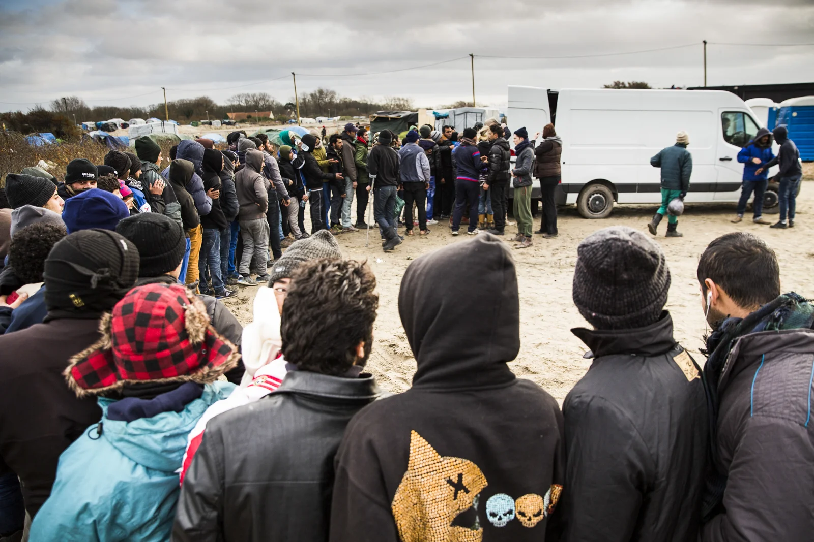 Dozens on migrants queue for food handouts in the Jungle Camp in Calais.