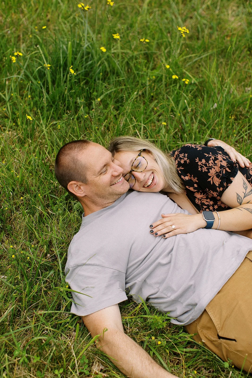 a couple laying in the grass laughing