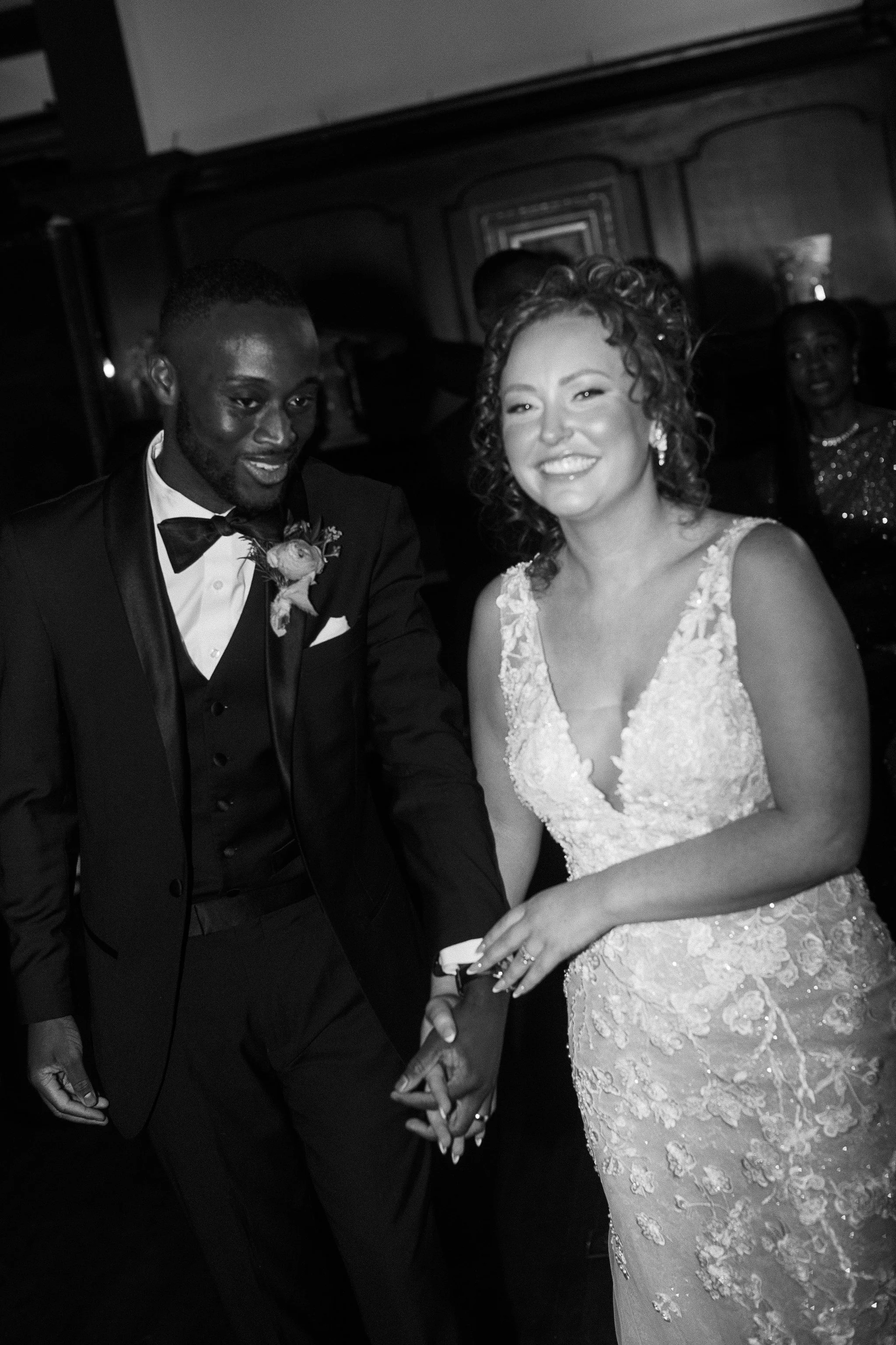 A couple smiling and holding hands, wearing formal wedding attire. gramercy mansion maryland wedding