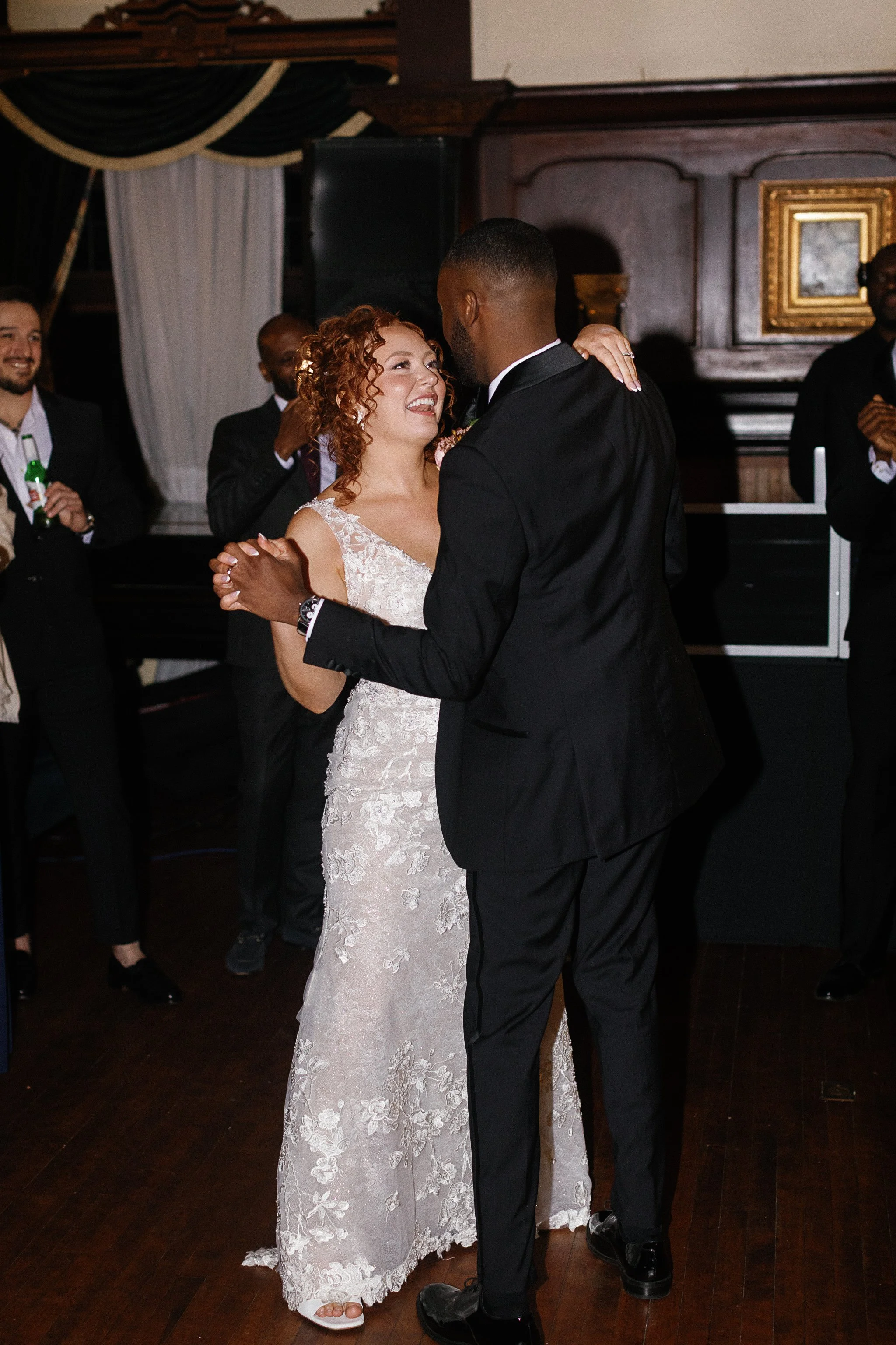 Bride and groom dancing at wedding reception with guests watching in the background. gramercy mansion maryland wedding