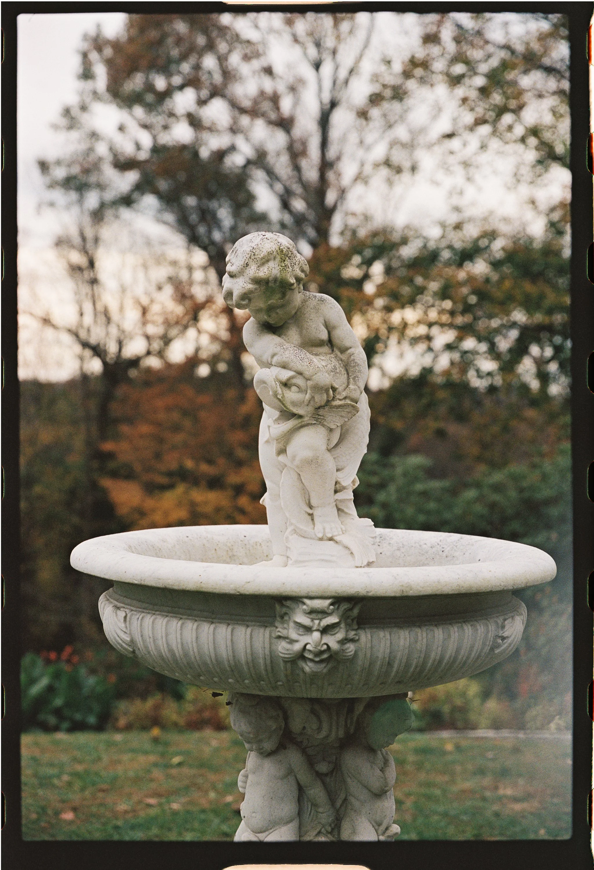 Stone fountain with cherub statue in garden setting gramercy mansion maryland wedding