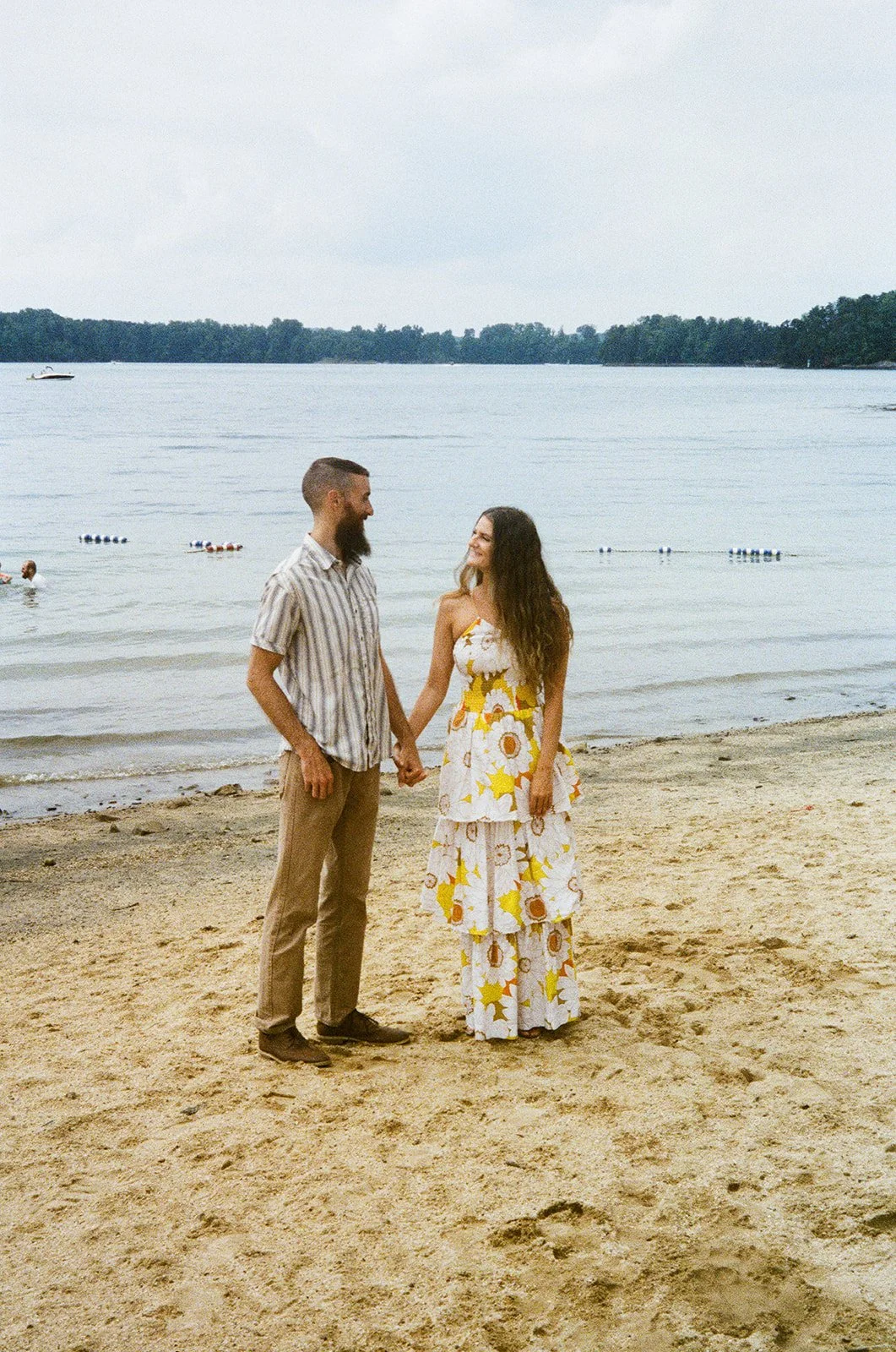 a couple holding hands on a beach at smith mountain lake