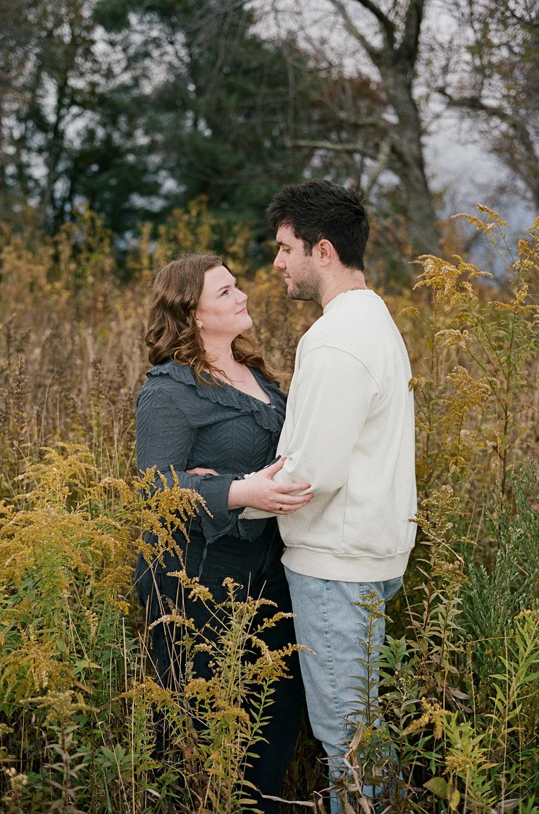 a couple kissing in a golden meadow of grass at cahas mountain overlook near roanoke virginia