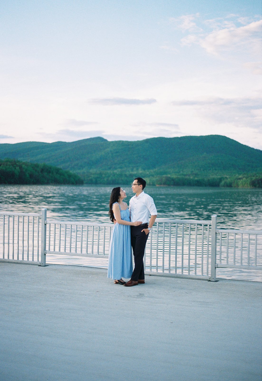 a couple embracing eachother on a fishing pier at carvins cove reservoir